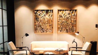 Espacio de estilo lujoso con sillones y obras de arte, reflejo del servicio de Magistrar
