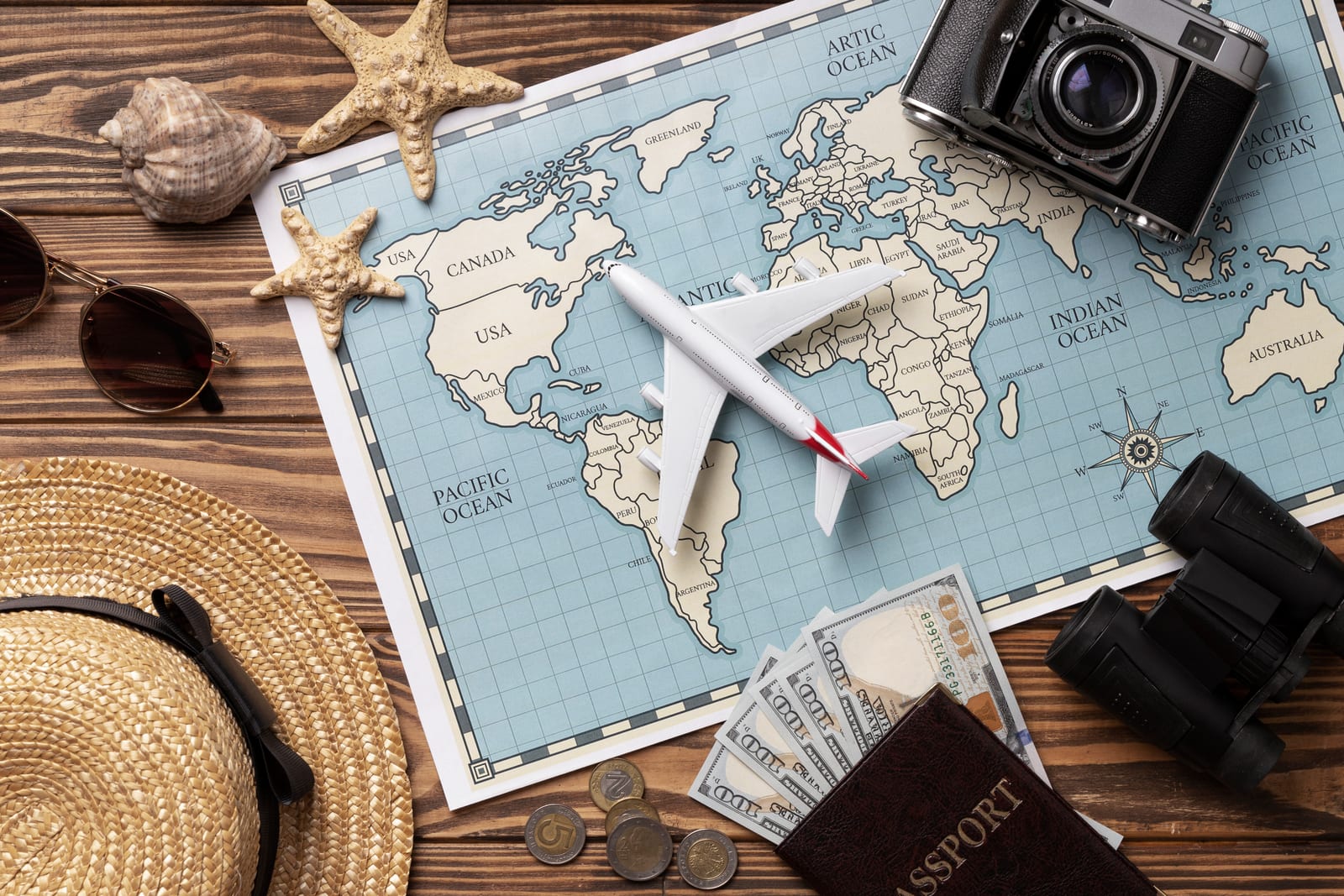 Mapa del mundo con avión, pasaporte y cámara para planificar un viaje de lujo